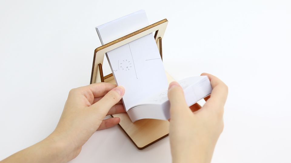 FLIPBOKU HOLDER - a practical tool that will enrich your experience with our interactive flip books Molecularis, Blanko and Dots &amp; Lines. It gives you some more freedom of movement while coloring, drawing, or connecting the dots.