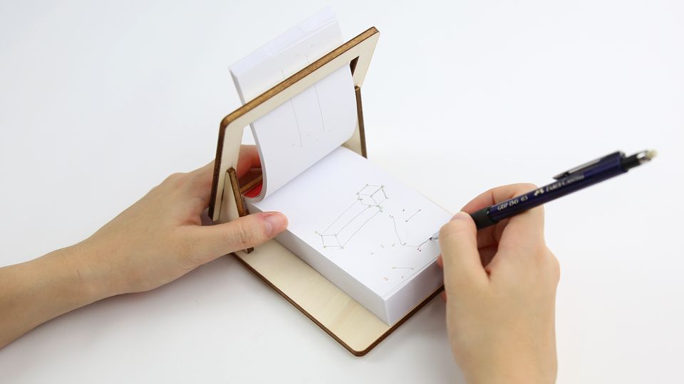 FLIPBOKU HOLDER - a practical tool that will enrich your experience with our interactive flip books Molecularis, Blanko and Dots &amp; Lines. It gives you some more freedom of movement while coloring, drawing, or connecting the dots.